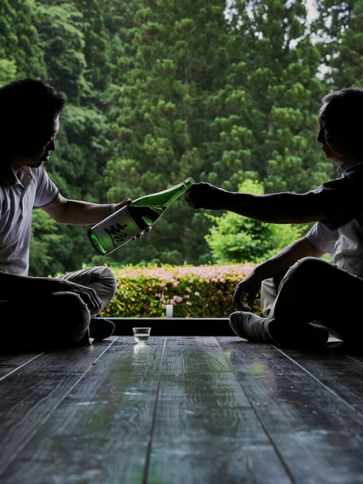 A scene of two people drinking local sake
